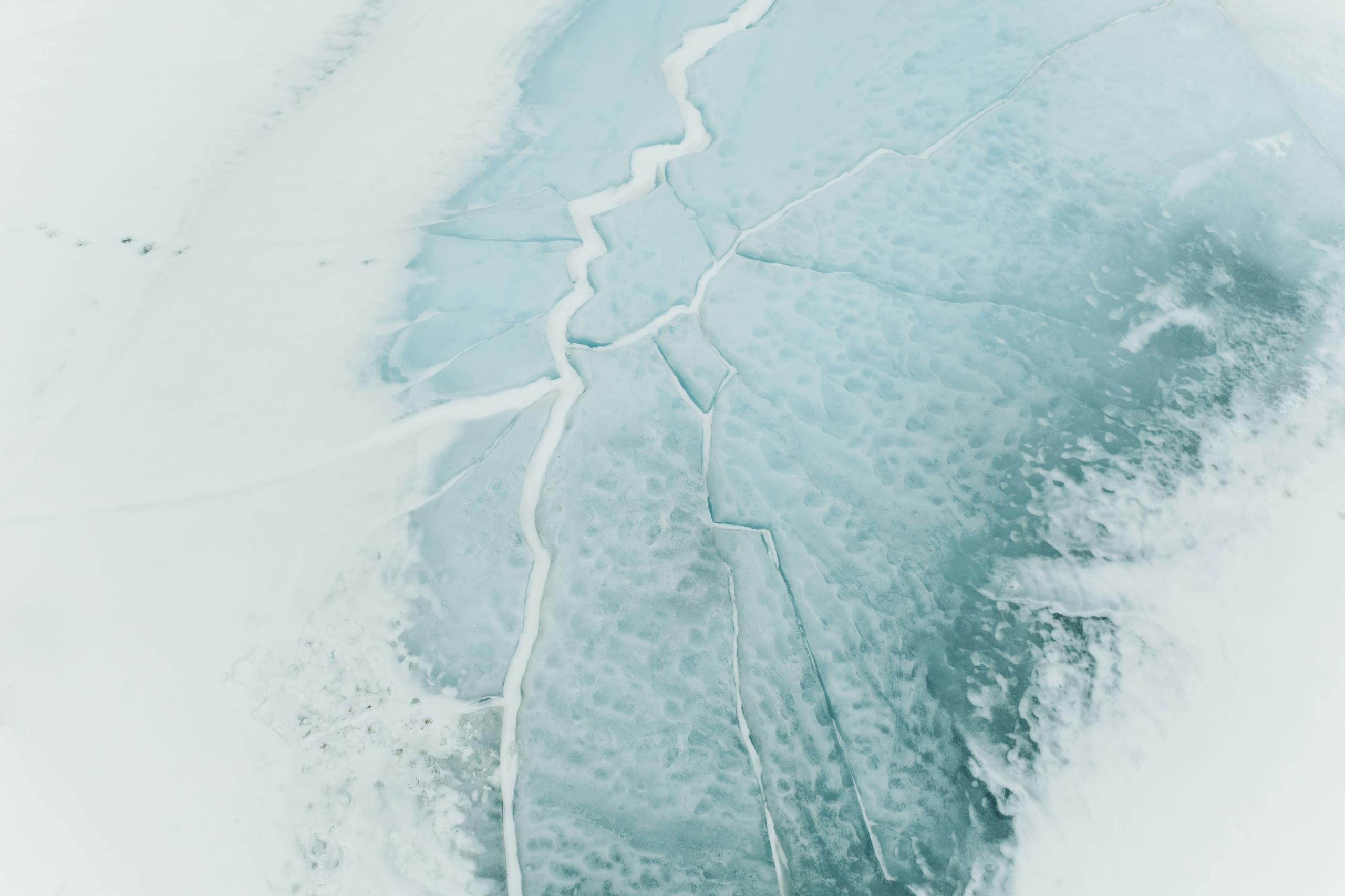 A captivating aerial view of cracked icy surface in a winter landscape in Siberia, Russia.