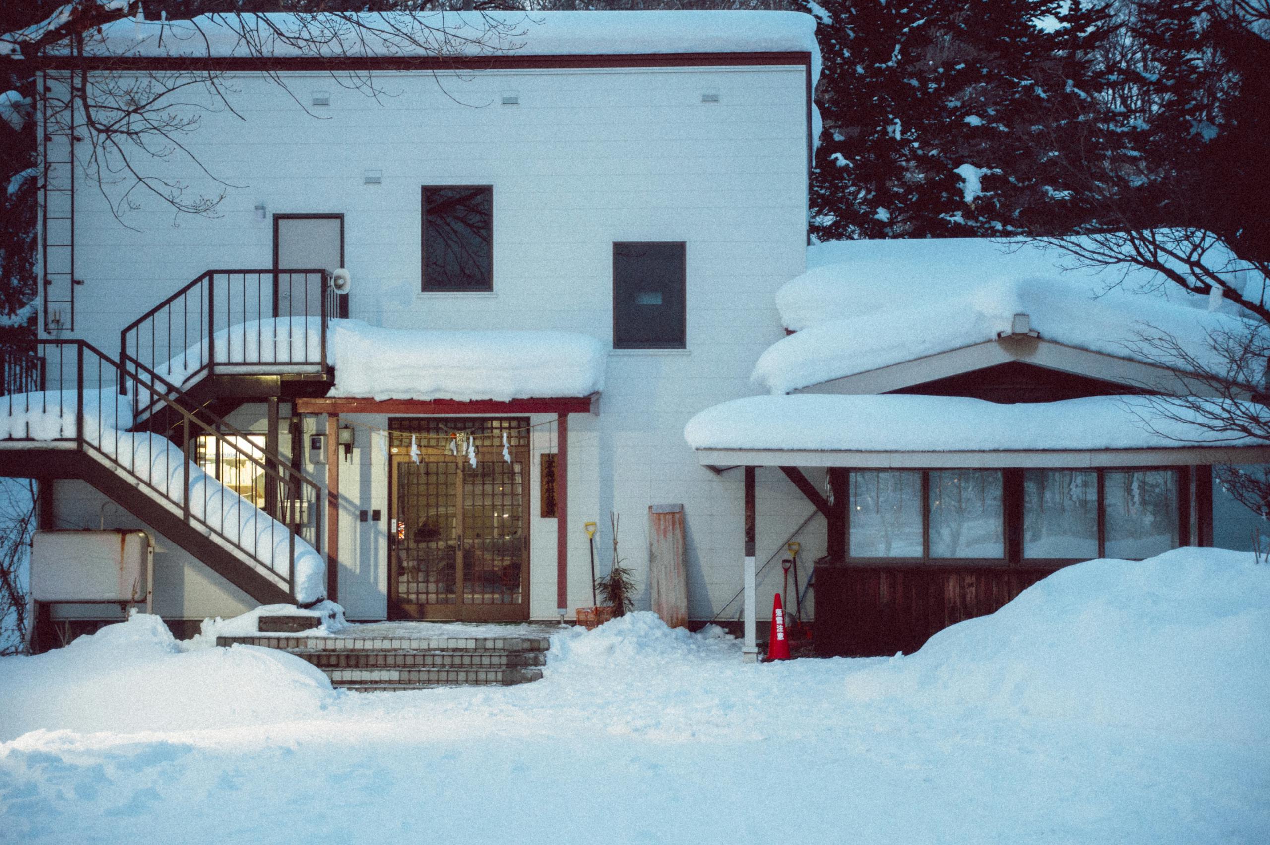 Charming snow-covered house in Hokkaido, Japan, showcasing a tranquil winter setting.