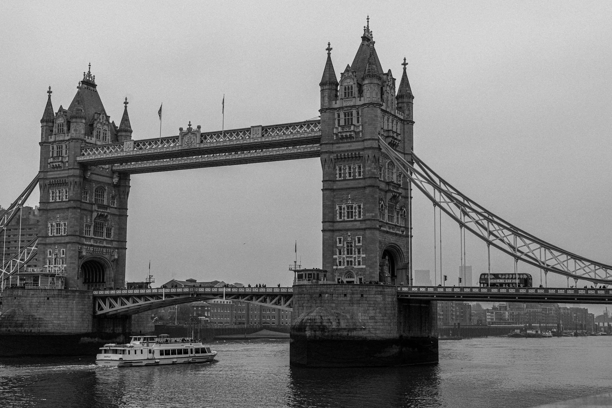 A classic black and white photograph of the historic Tower Bridge over the Thames in London.