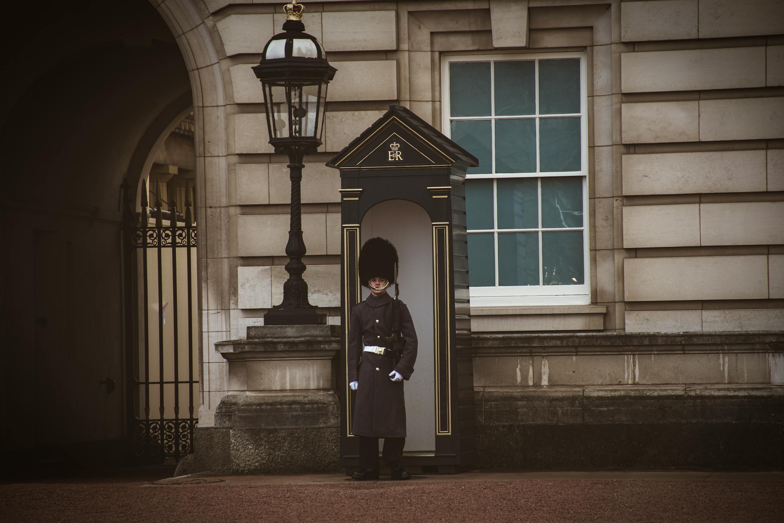 Buckingham Palace guard in ceremonial uniform stands at attention, London landmark.