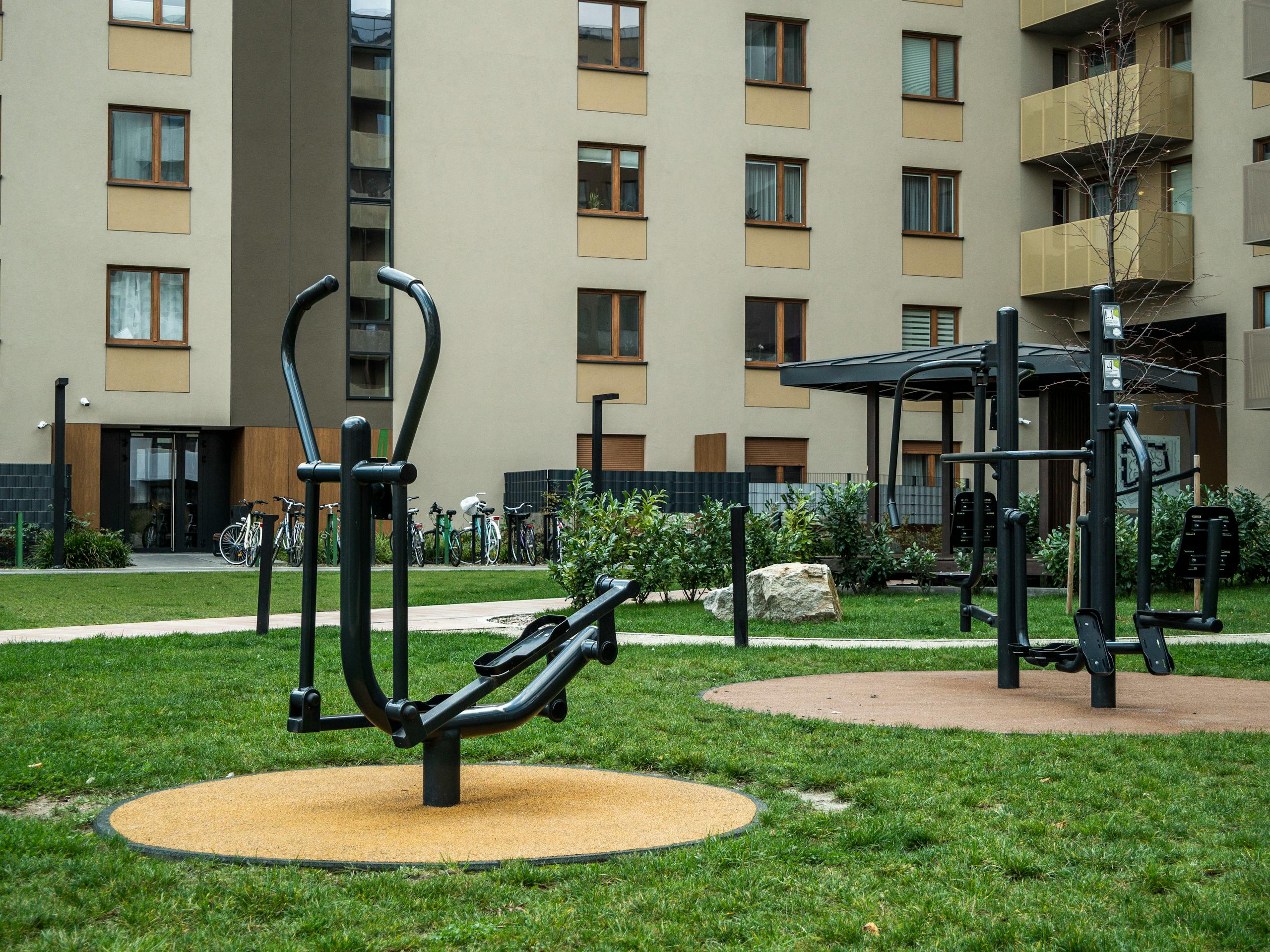 Modern outdoor gym equipment in a residential courtyard, promoting fitness and healthy lifestyle.