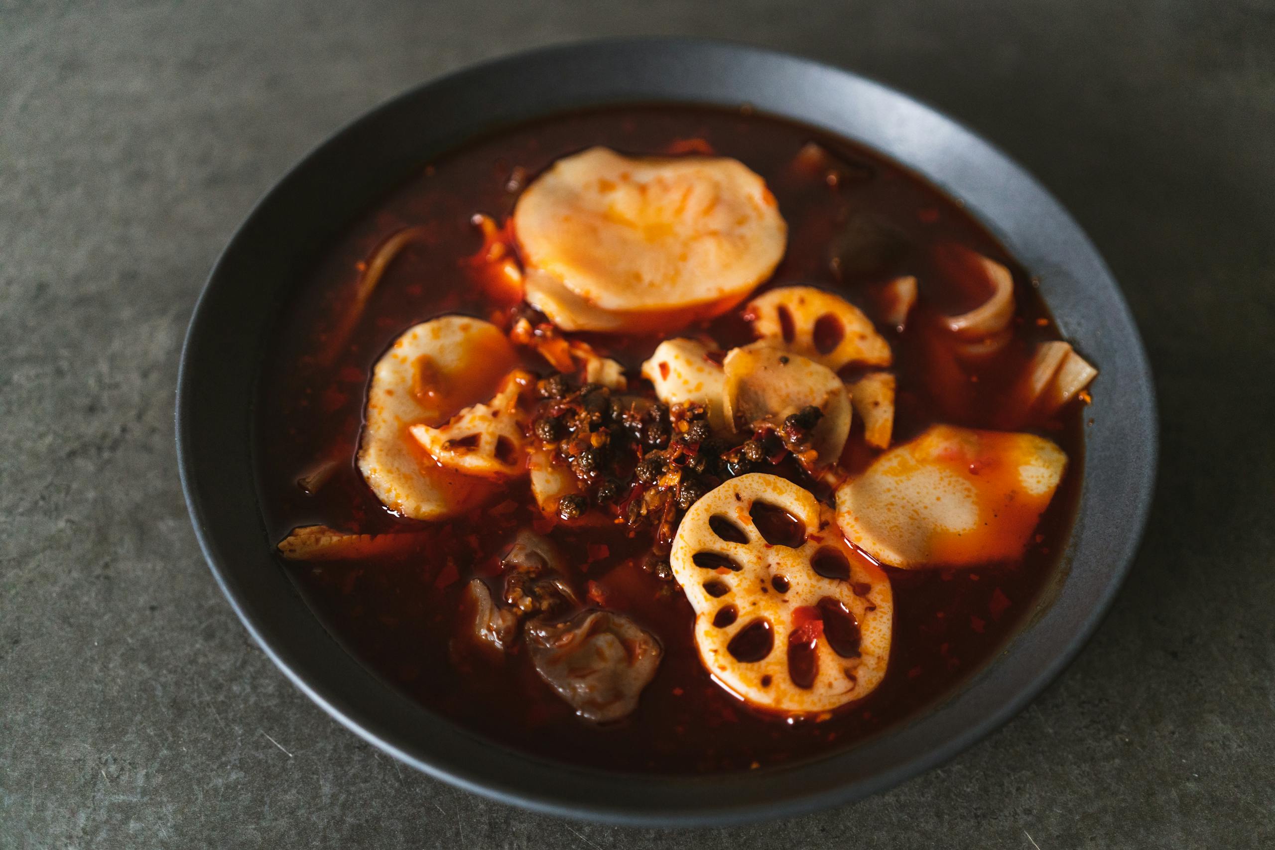 A delicious bowl of Sichuan hotpot featuring lotus roots and potatoes in spicy broth.