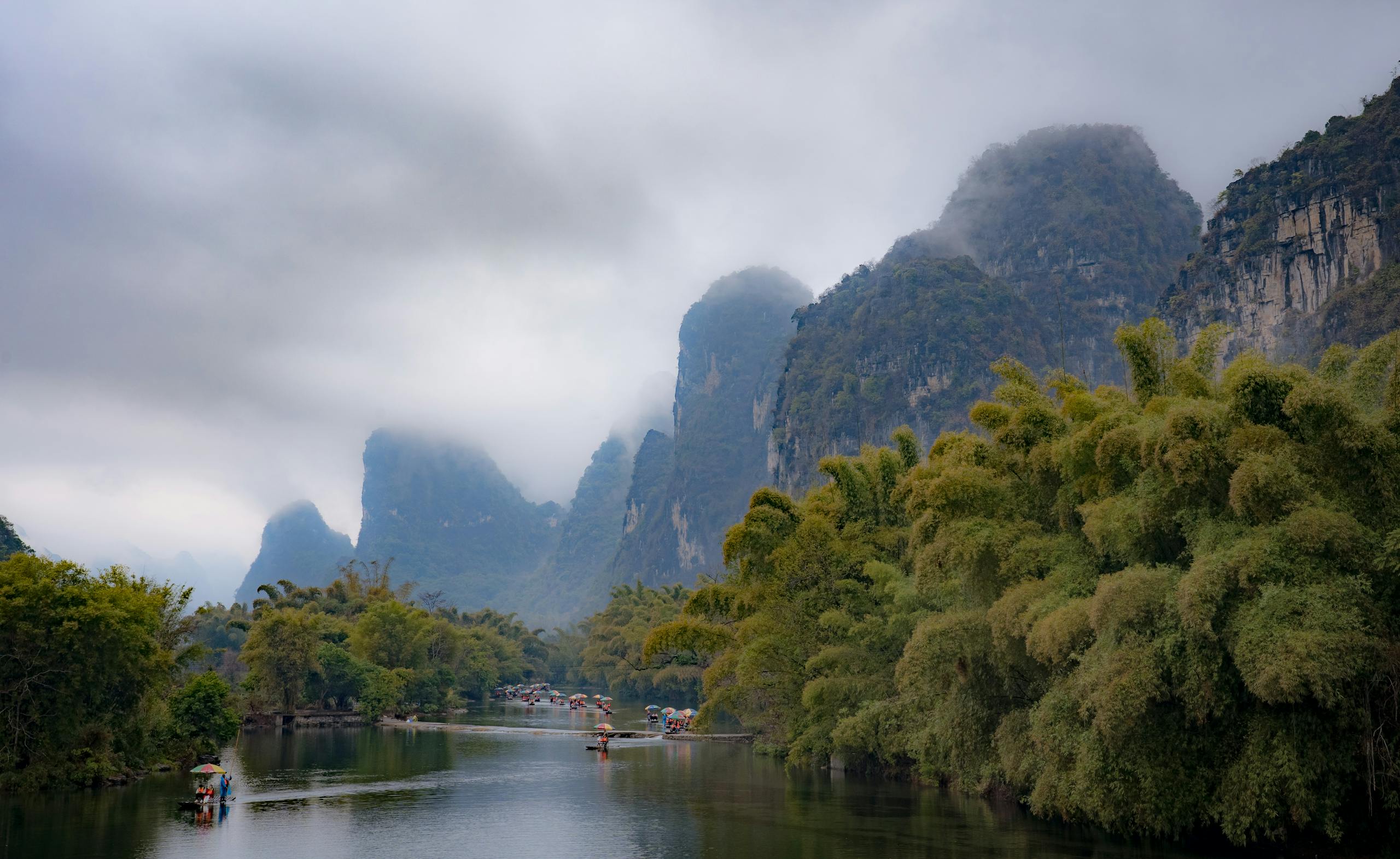 Breathtaking karst mountains in misty Guilin, China with river scenery and lush greenery.