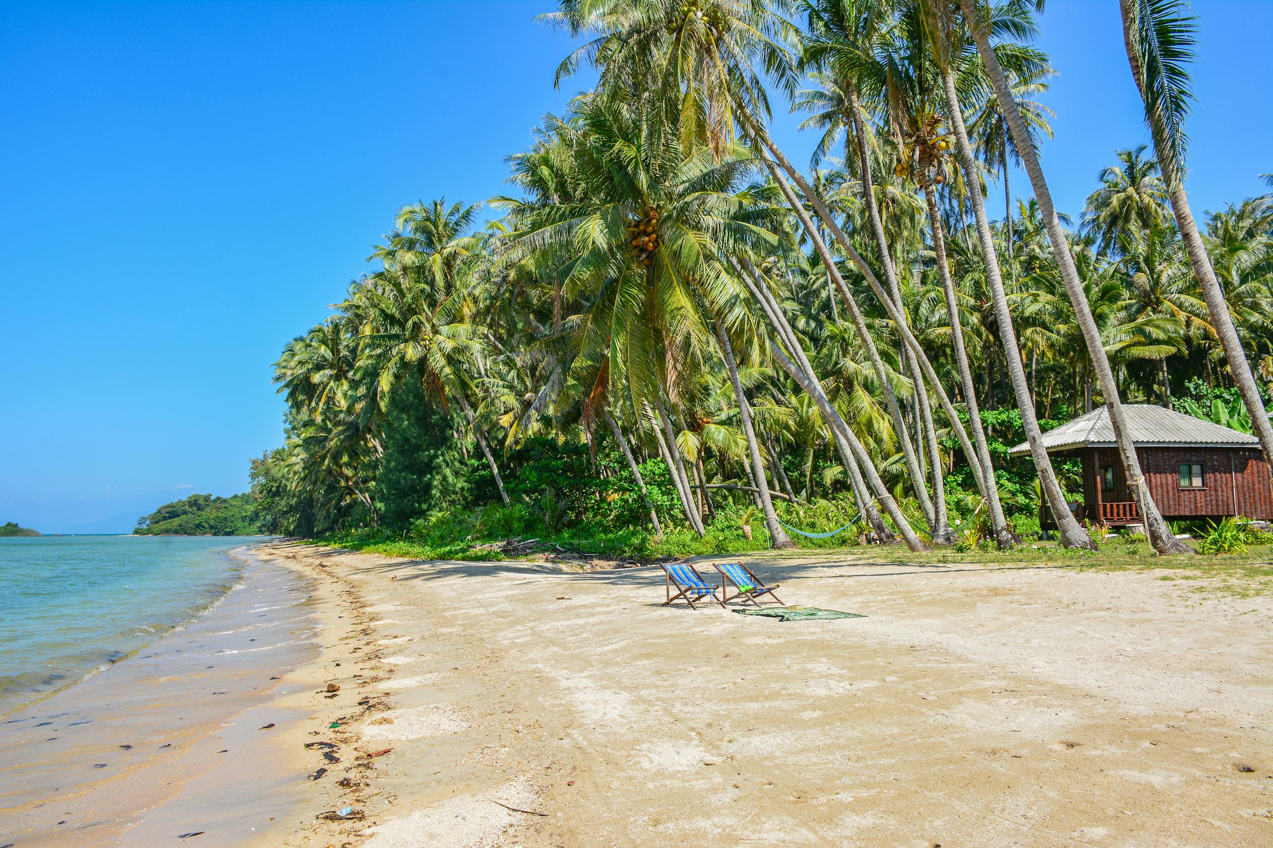 Stunning tropical beach on Ko Mak island, Thailand, with palm trees and clear blue skies.