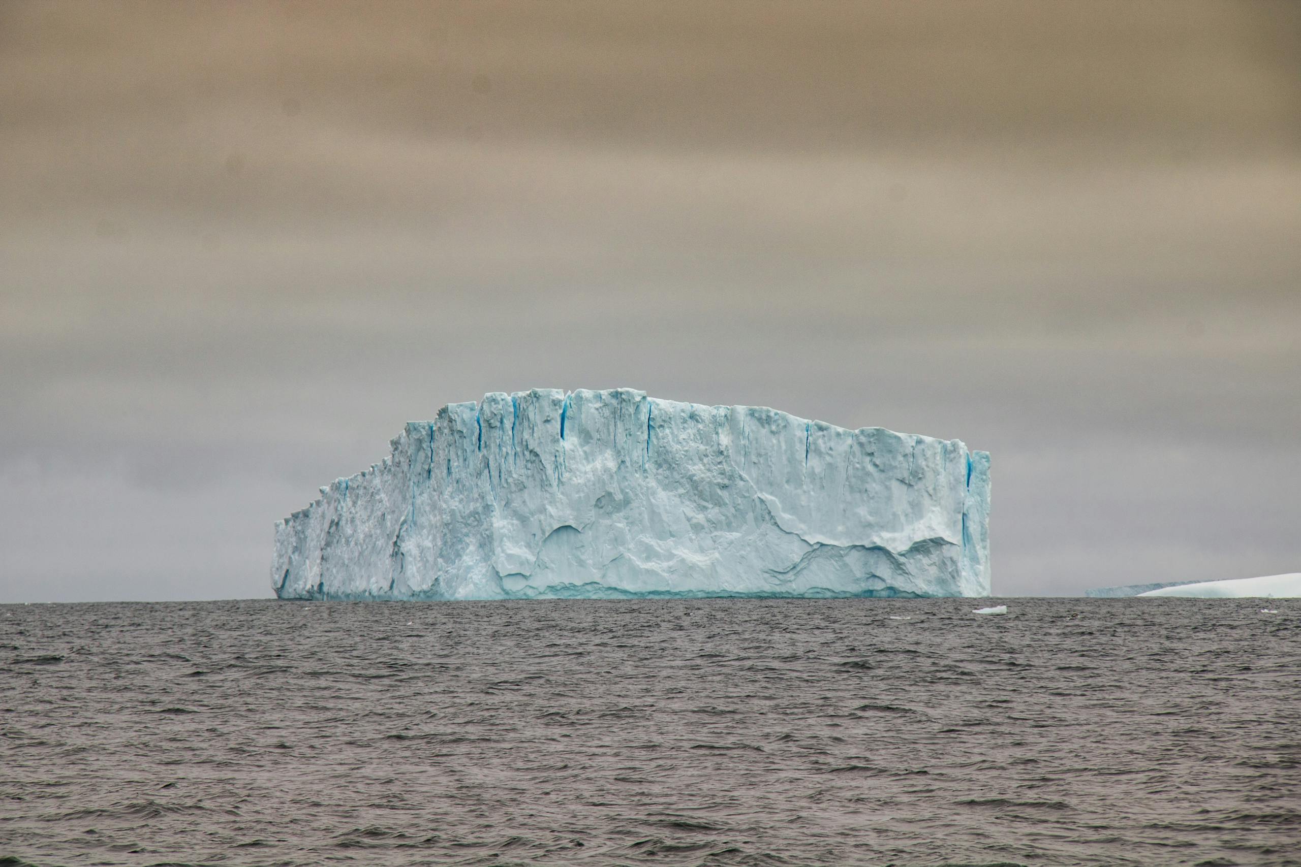 Stunning view of a massive iceberg in Antarctica, symbolizing the beauty and fragility of polar environments.