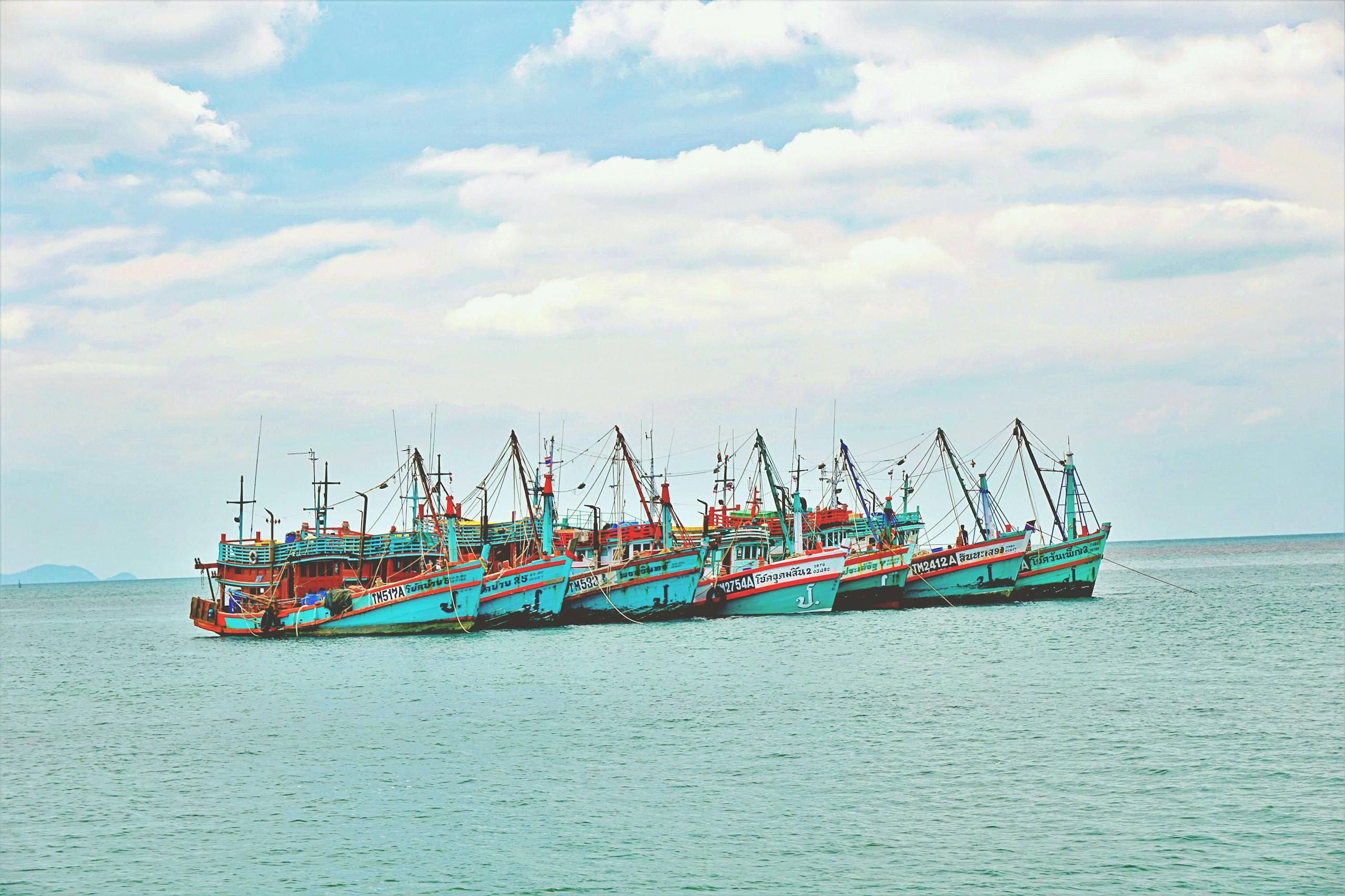 A vibrant cluster of fishing boats floating peacefully on the Gulf of Thailand.