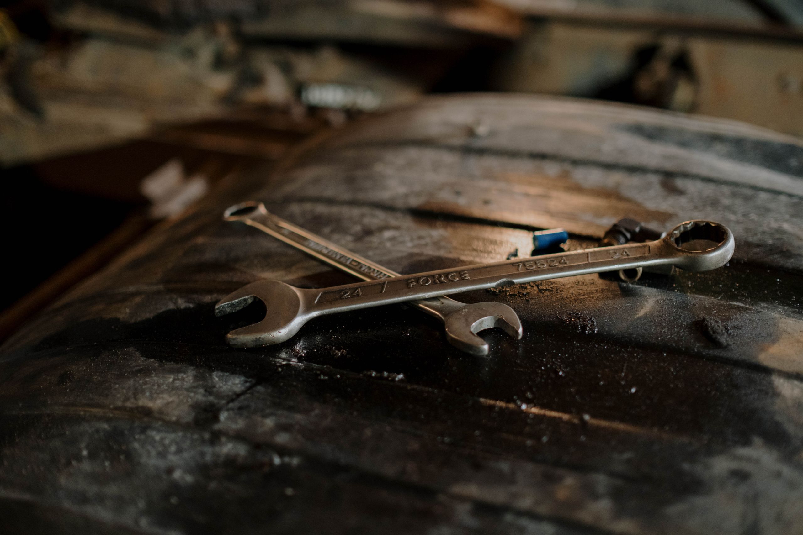 Close-up view of wrenches placed on a textured surface in a workshop setting.